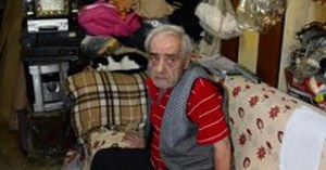 Babası için sahte bir mezarın önünde poz vermişti